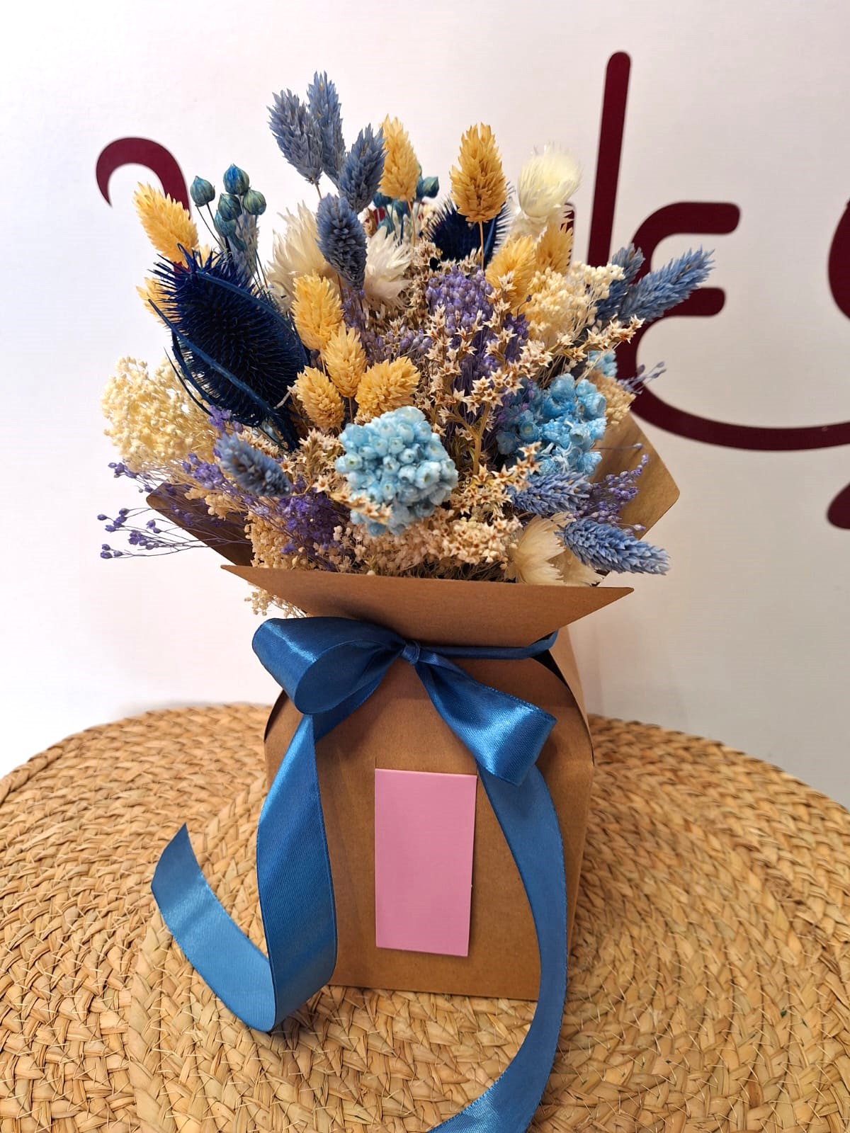 Ramillete de flor seca en tonos azules y beige presentado en caja